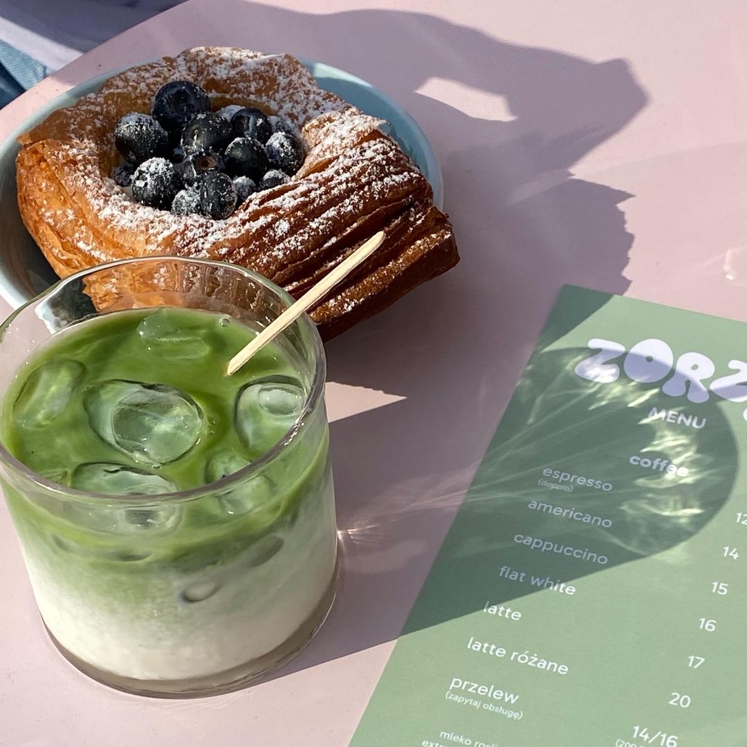 Matcha i słodki wypiek na różowym stole w ZORZY